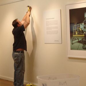 Volunteer helping to hang exhibits